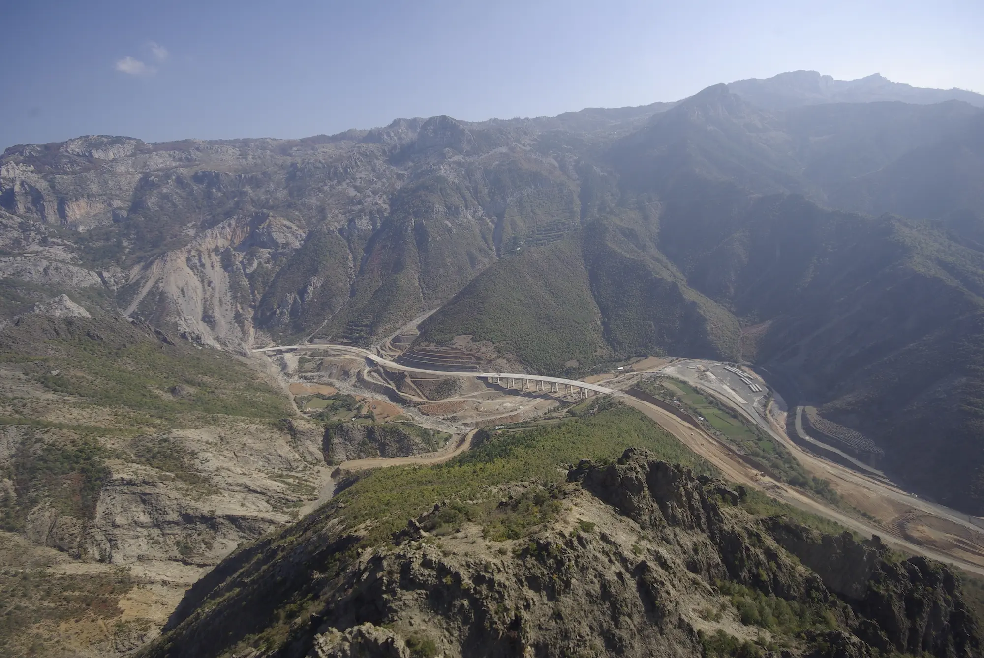 Aerial view of motorway cutting through a mountainous, rocky area.