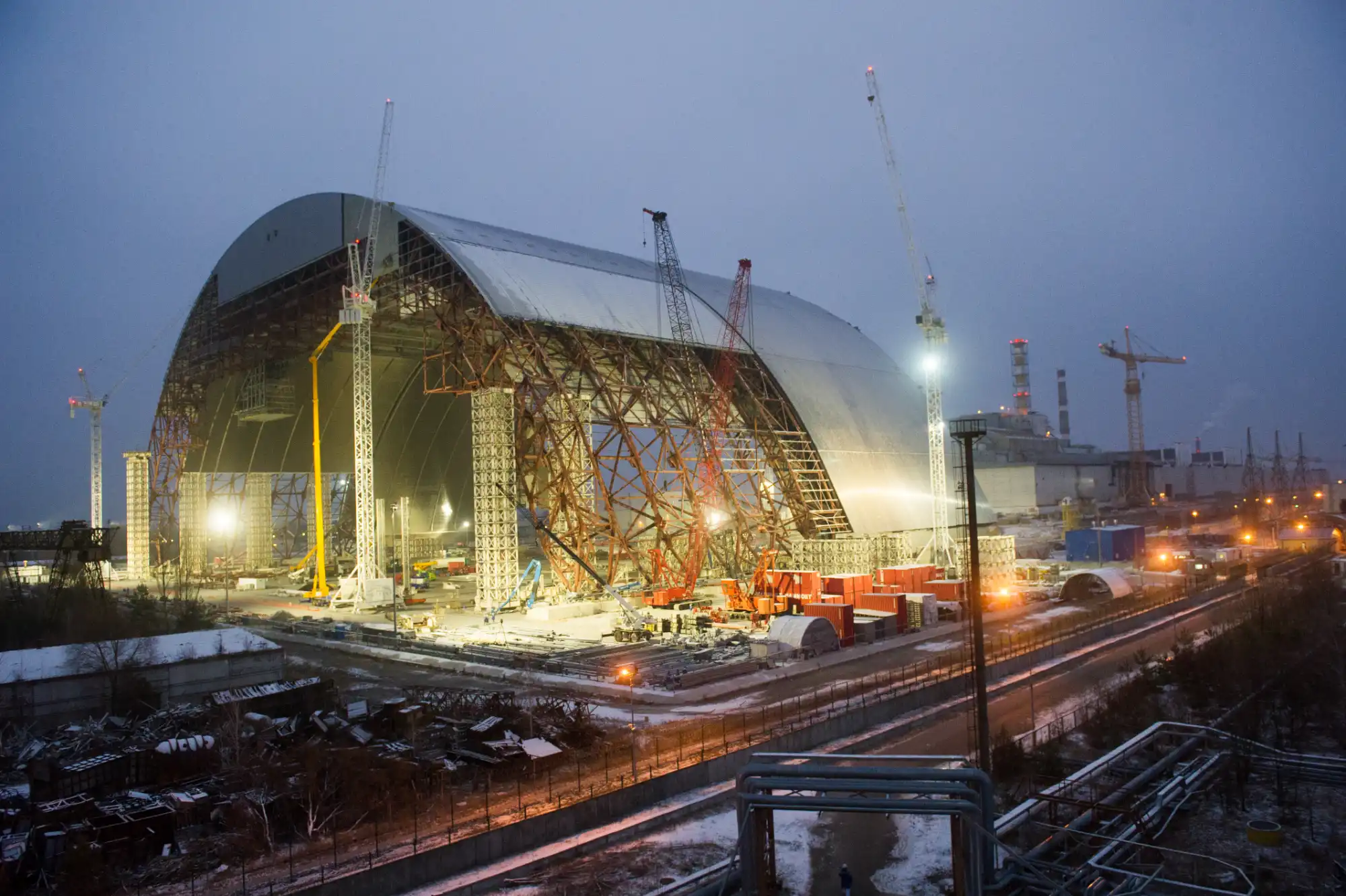 Workers cover the exterior of the New Confinement Shelter