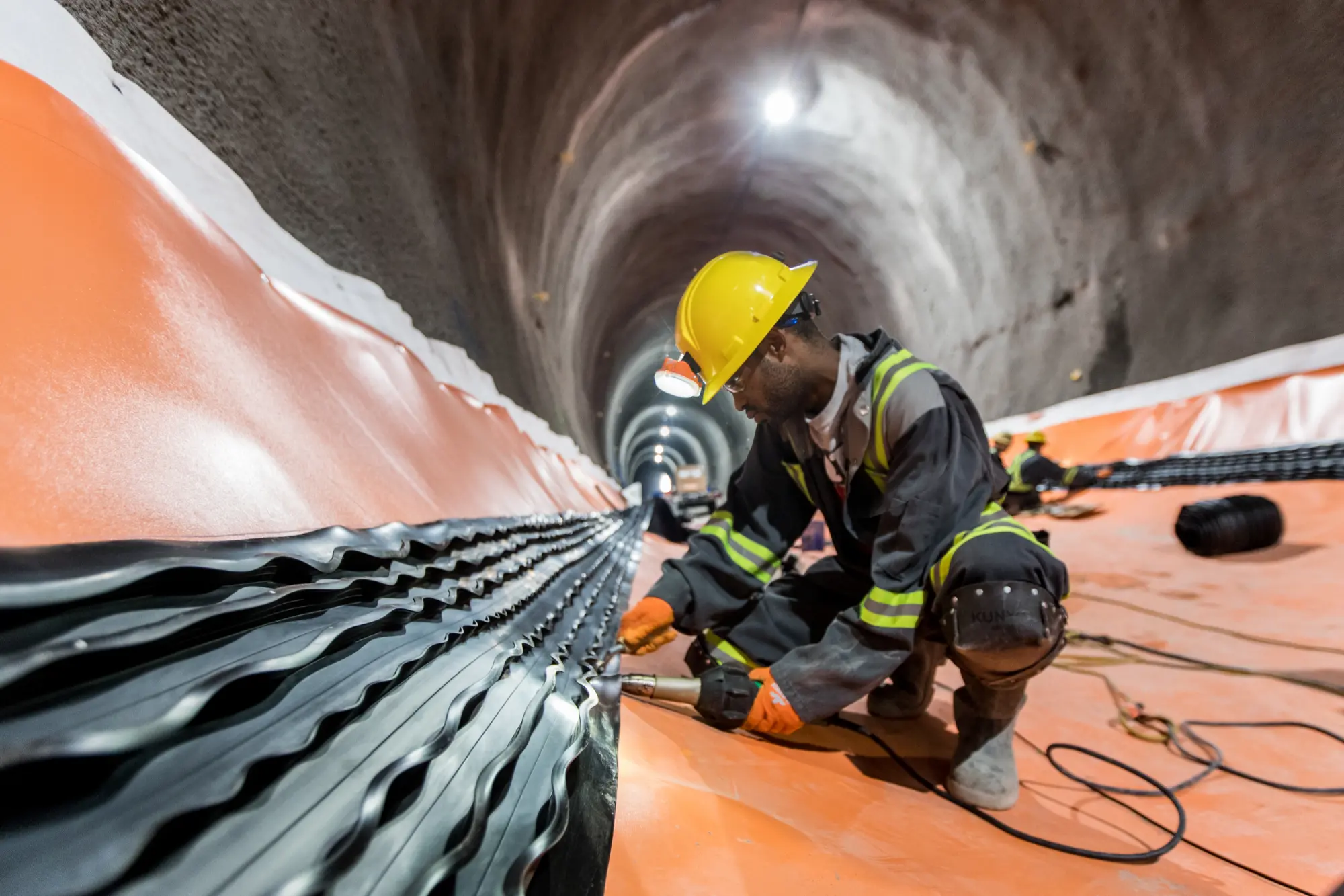 A TransEd worker installs waterproofing in the southbound tunnel in the North River Valley construction area.